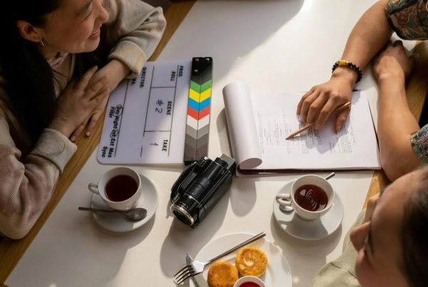 People gathered around a Table; 8 Ways to Get Visibility for Your Script