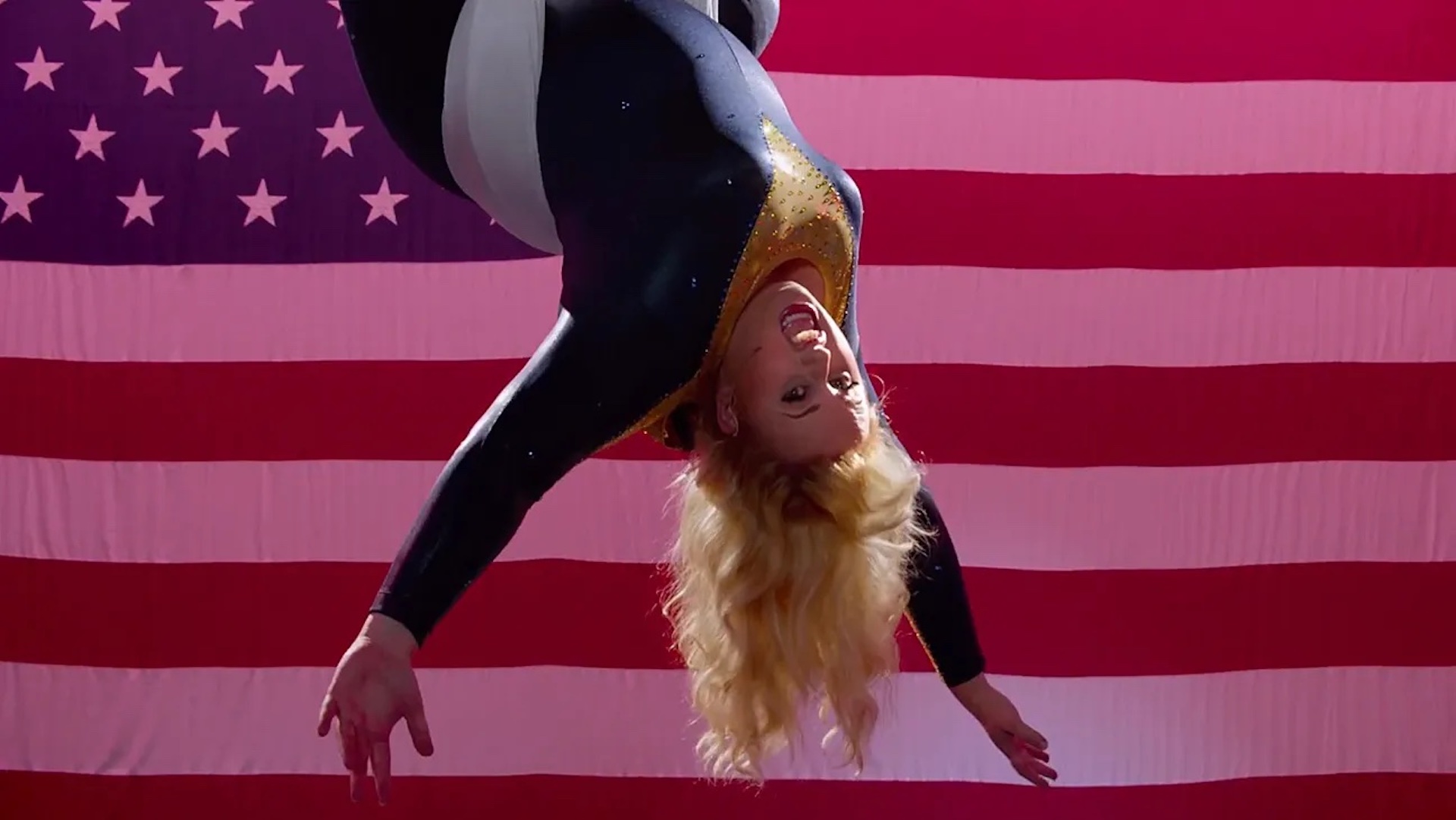 Fat Amy (Rebel Wilson) dangling from the rafters in front of an American flag in 'Pitch Perfect 2,' How You Can Embrace Size Inclusivity in Your Screenplay
